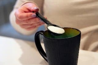 Menuangkan memasukkan gula pasir ke dalam gelas